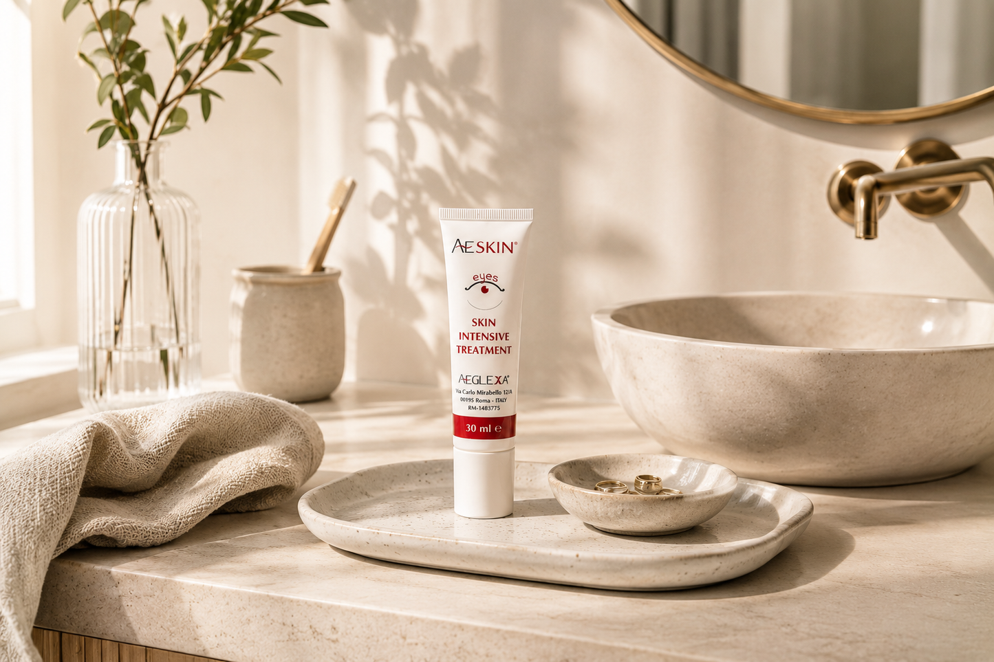 Tubetto AESKIN Eyes 30 ml su vassoio di ceramica in un bagno con rubinetteria in ottone